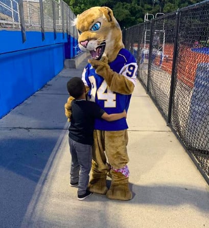 kid hugging mascot